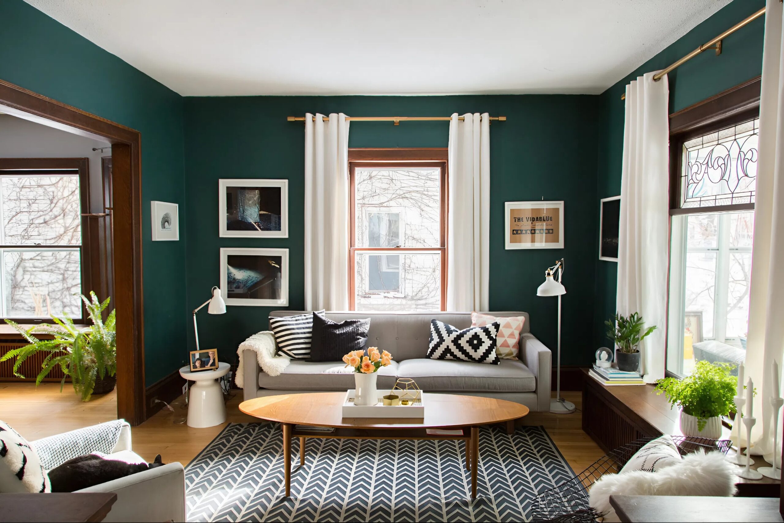 Living room with deep green painted walls with clean white trim by a house painter in Ankeny, IA